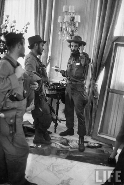 Cuban rebel Camilo Cienfuegos (L) talking on the phone in the Presidential palace. Havana 1959